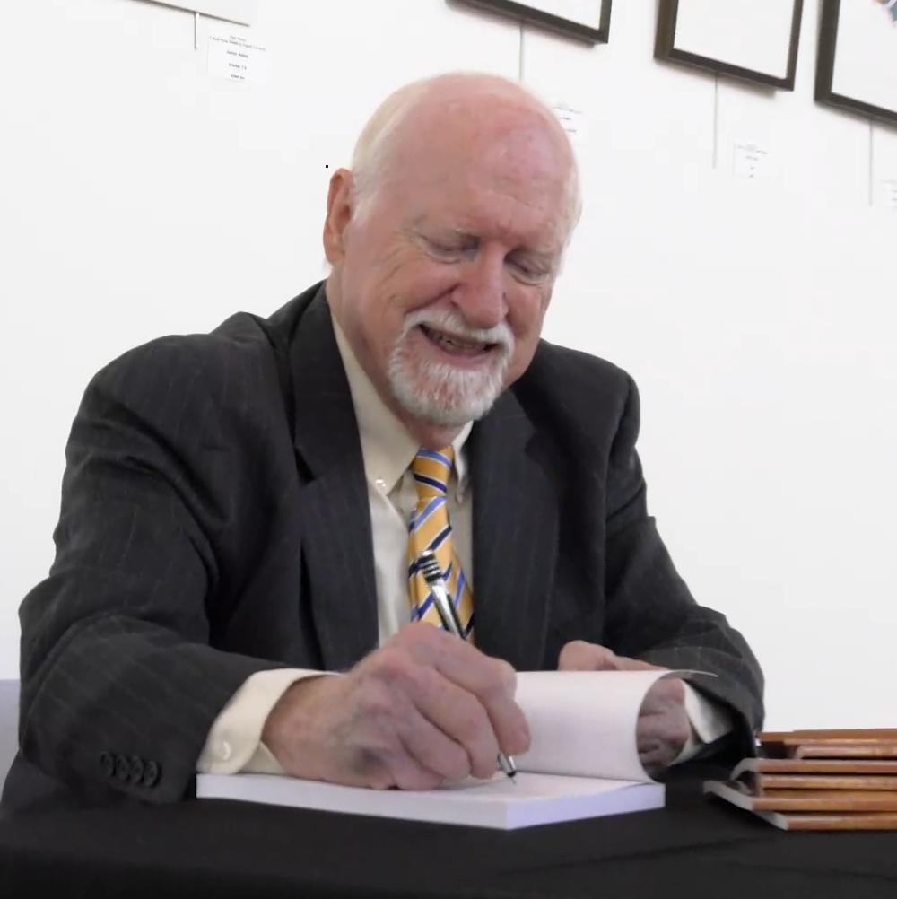 Dr. Mike Armour signing books following a keynote speech.